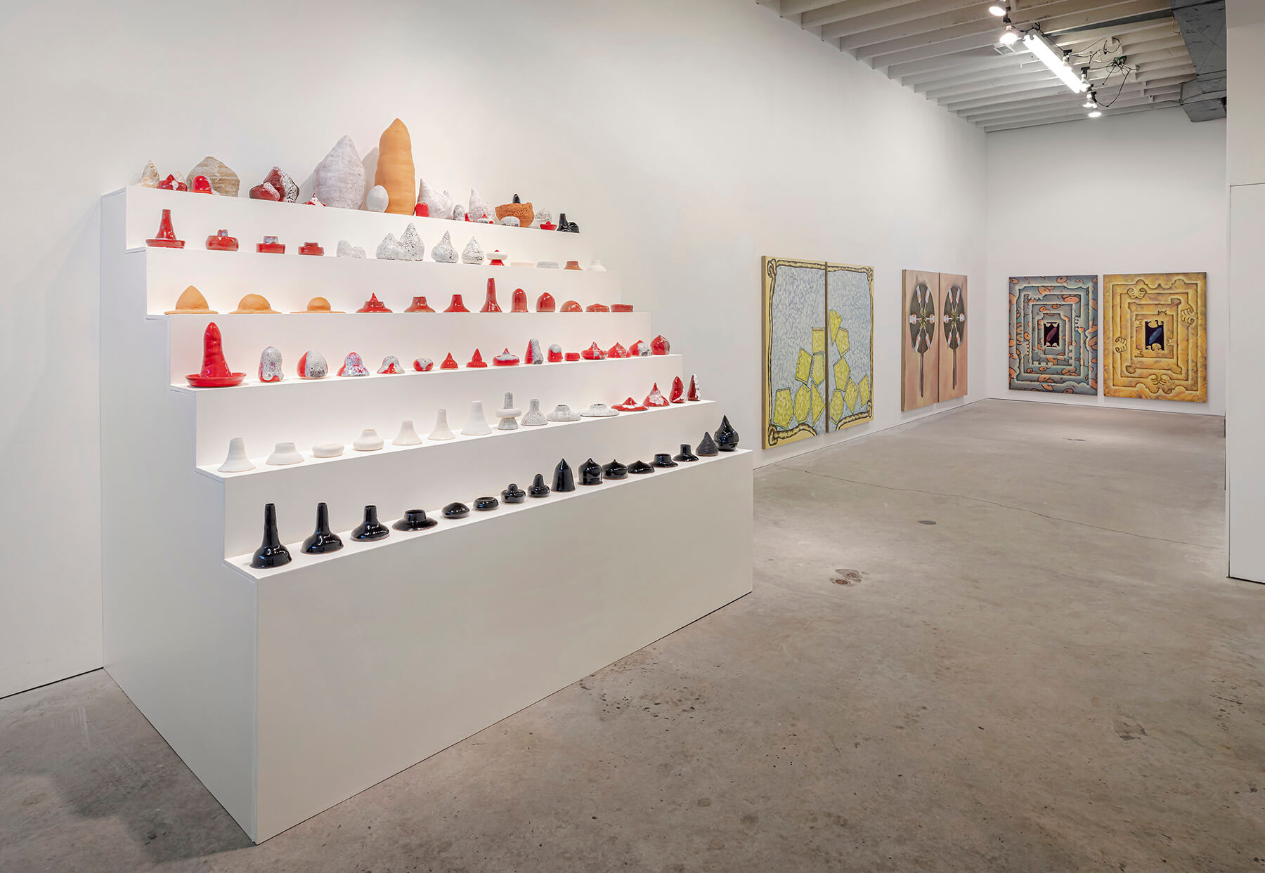 Installation view of the sculptures next to the large oil paintings.