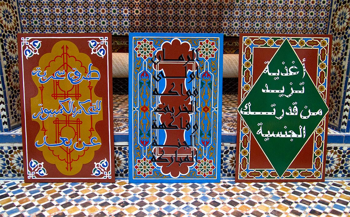 Three posters standing against a mosaic background.