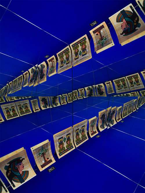 A blue display case with mirrored walls creating an optical illusion of cards containing Egyptian iconography.