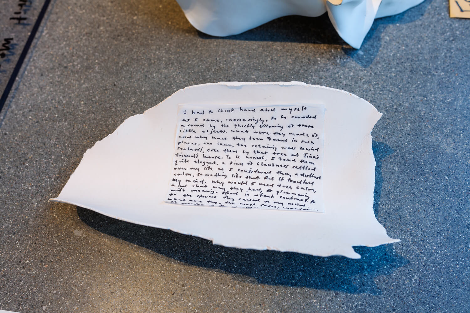 A hand written note placed on the concave side of a small sculpture.