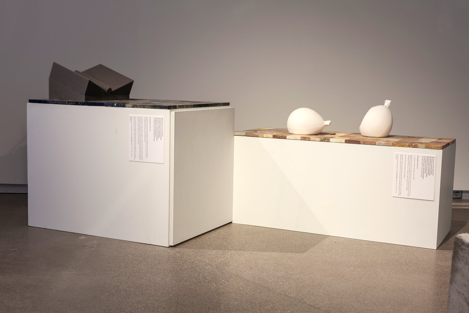 Two large plinths containing sculptures.