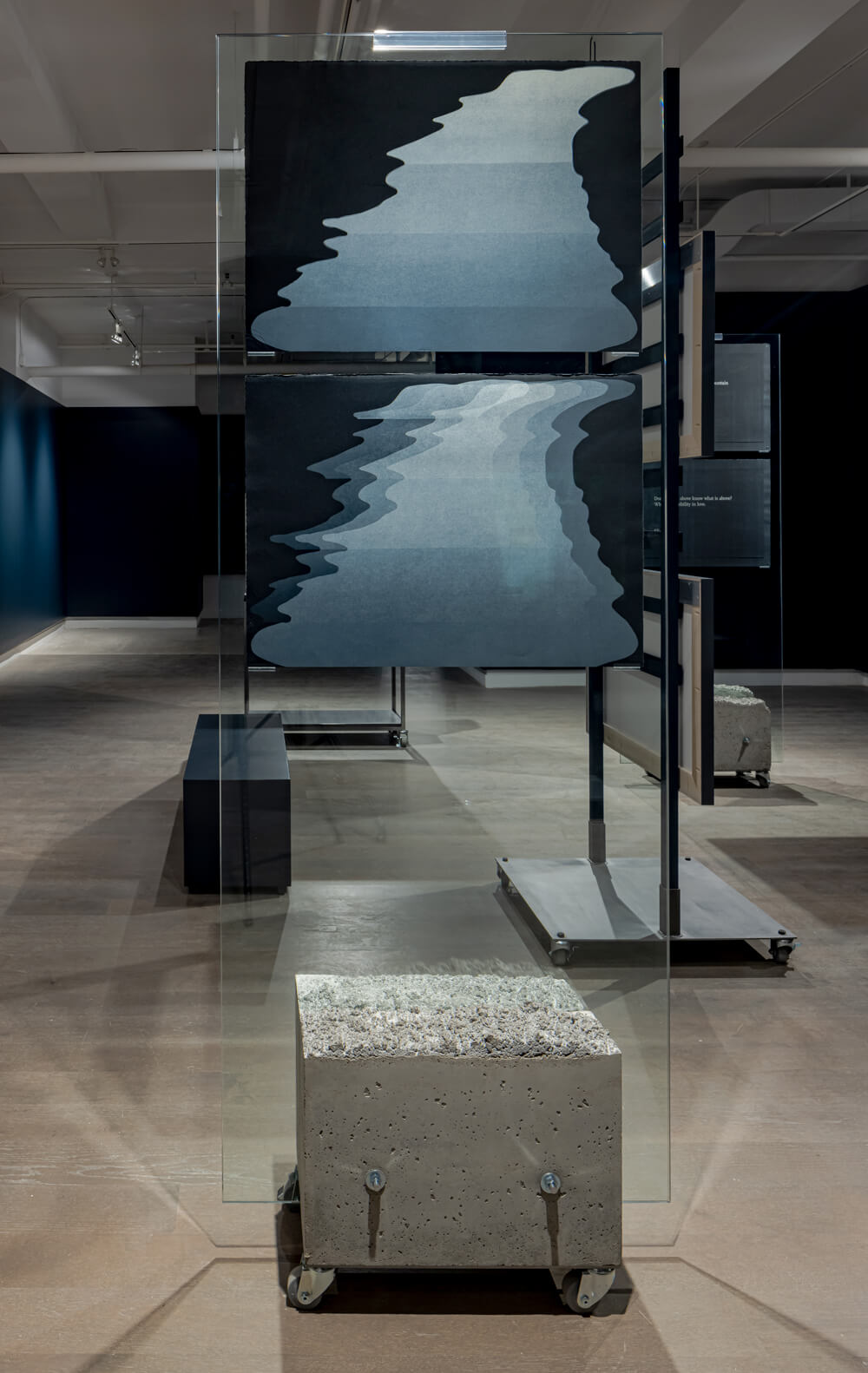 Installation view of blue-greys print hanging on a glass panel.