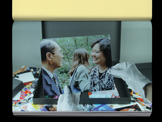 Hands wearing white archive gloves holding a photograph of two people interacting.